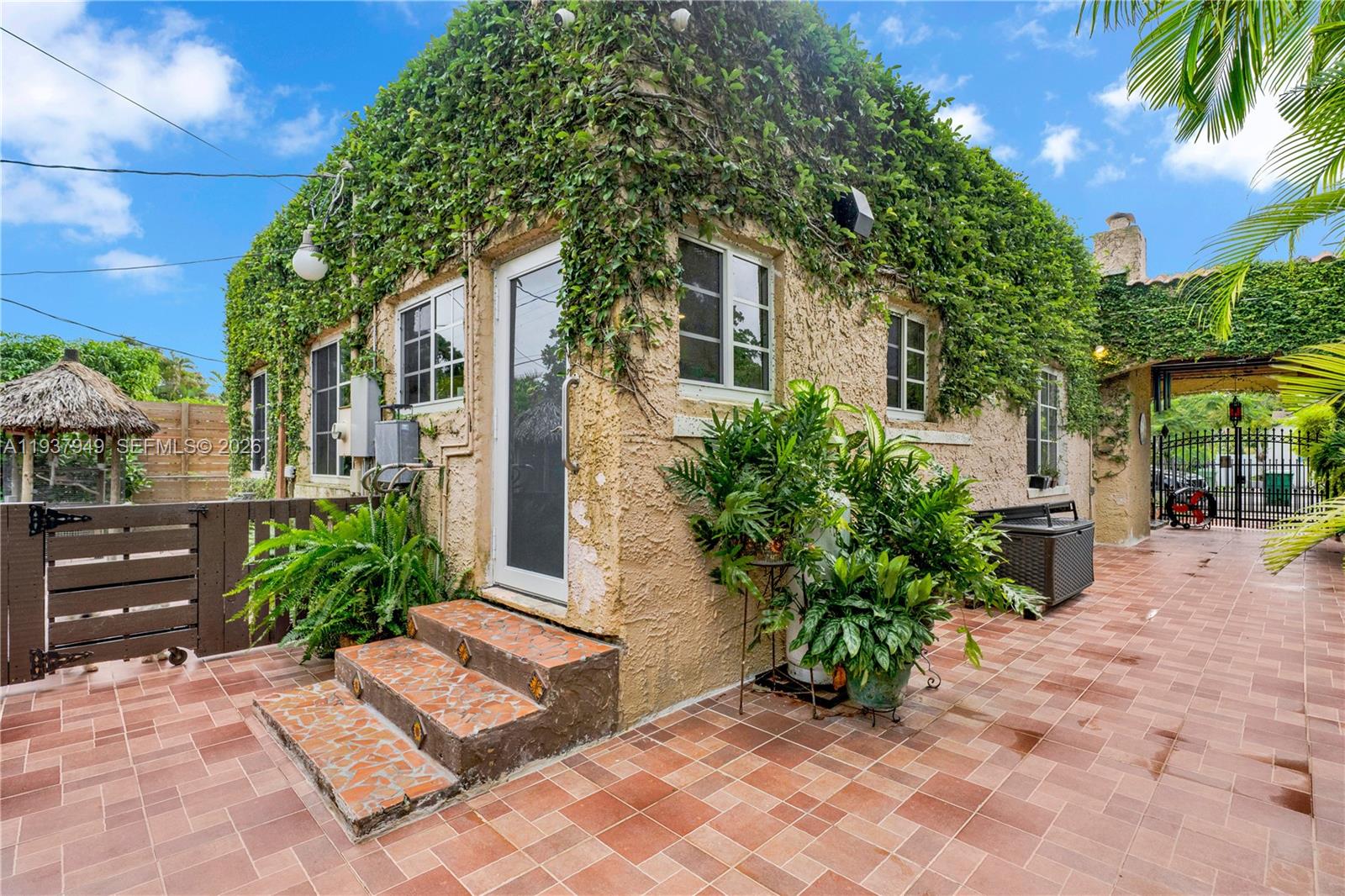 4739 Southwest 5th Street Miami, FL 33134 - Photo 7 of 40 a view of a house with potted plants and a bench