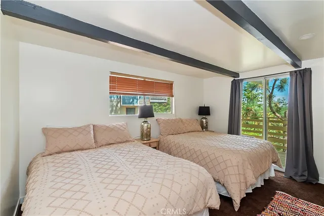 a bedroom with two beds and a large window