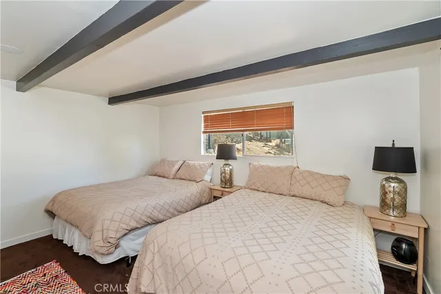 a bedroom with two beds and a flat screen tv