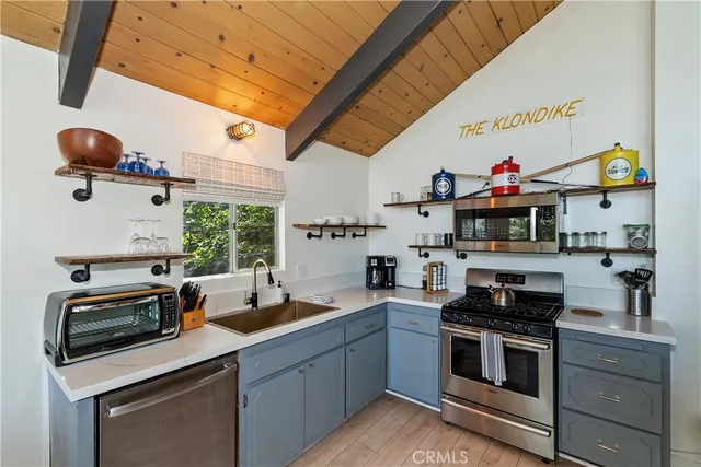 a kitchen with stainless steel appliances granite countertop a sink a stove and a microwave