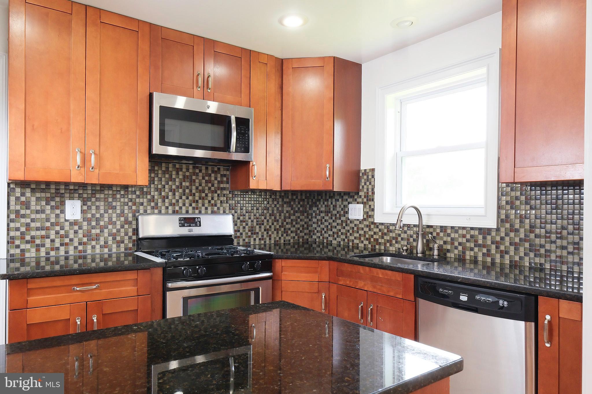 12720 Feldon Street Silver Spring, MD 20906 - Photo 8 of 13 a kitchen with stainless steel appliances granite countertop a stove a sink and a microwave