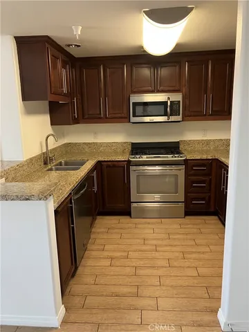 a kitchen with stainless steel appliances granite countertop a stove sink and cabinets