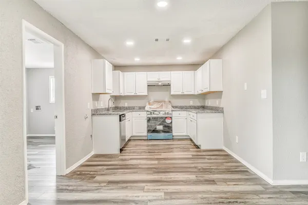 a kitchen with a refrigerator sink and cabinets