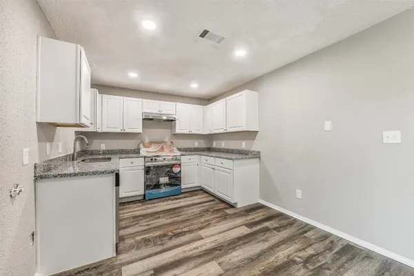 a kitchen with granite countertop white cabinets and white appliances