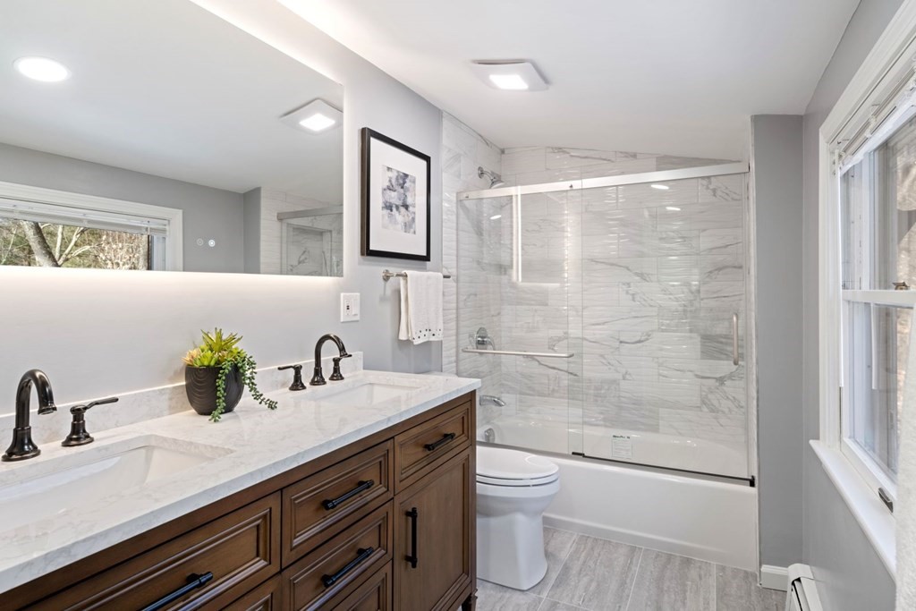 143 Grove Street Lexington, MA 02420 - Photo 21 of 34 a bathroom with a granite countertop sink a toilet and shower