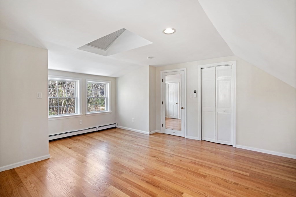 143 Grove Street Lexington, MA 02420 - Photo 22 of 34 a view of an empty room with wooden floor and a window