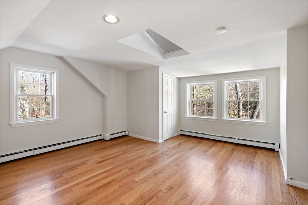 143 Grove Street Lexington, MA 02420 - Photo 23 of 34 a view of an empty room with wooden floor and a window