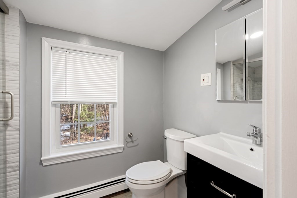 143 Grove Street Lexington, MA 02420 - Photo 25 of 34 a bathroom with a sink a toilet and a window
