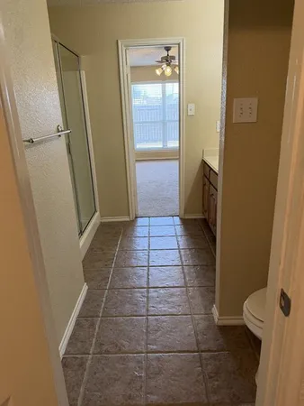 a white toilet sitting next to a white wall
