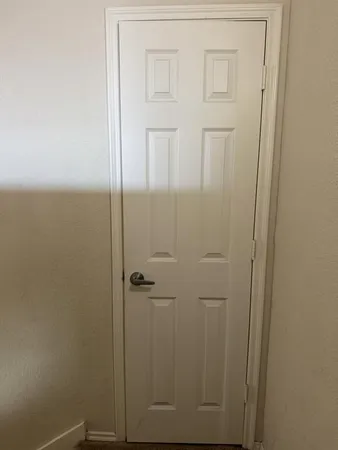 en empty room with windows and chandelier fan