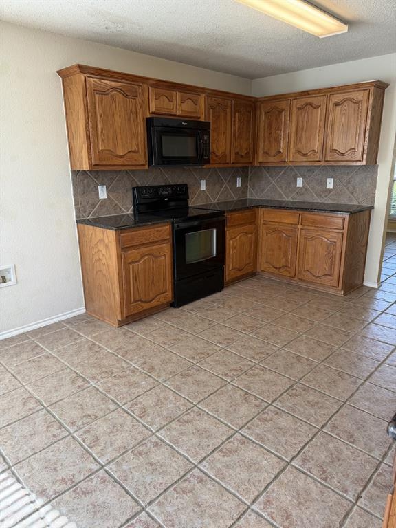 6505 Rienzi Drive Greenville, TX 75402 - Photo 8 of 40 a kitchen with stainless steel appliances granite countertop a stove a sink and a microwave