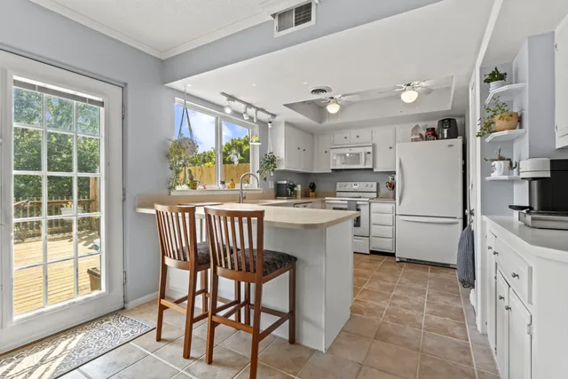 a kitchen with a table chairs refrigerator a sink dishwasher and cabinets