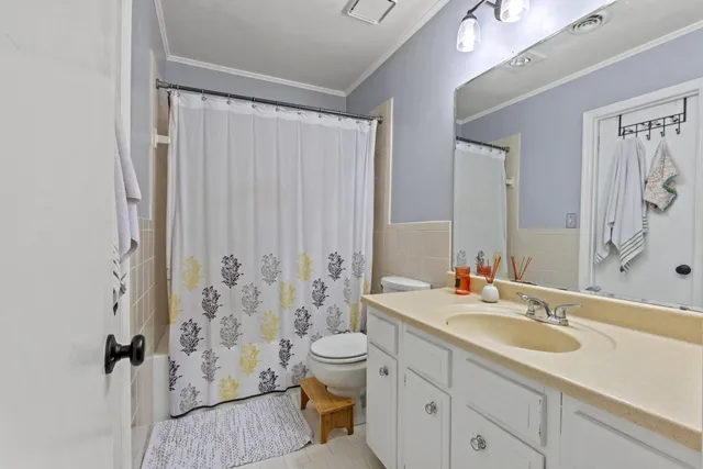 a bathroom with a sink toilet double vanity and shower