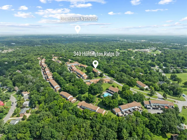 an aerial view of residential houses with outdoor space and trees