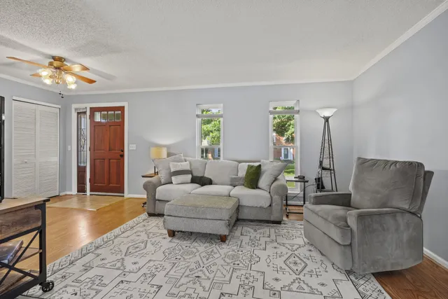 a living room with furniture and wooden floor