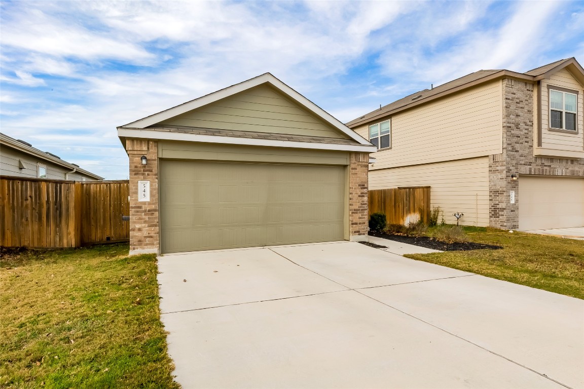 545 Greatest Gift Way Jarrell, TX 76537 - Photo 2 of 34 View of front of house with brick siding, a garage, driveway, and an outbuilding