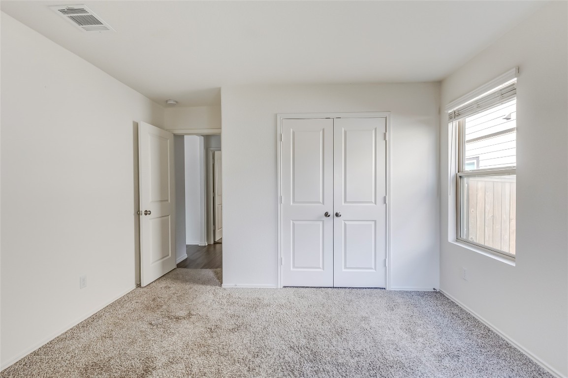 545 Greatest Gift Way Jarrell, TX 76537 - Photo 27 of 34 Unfurnished bedroom with light colored carpet and a closet