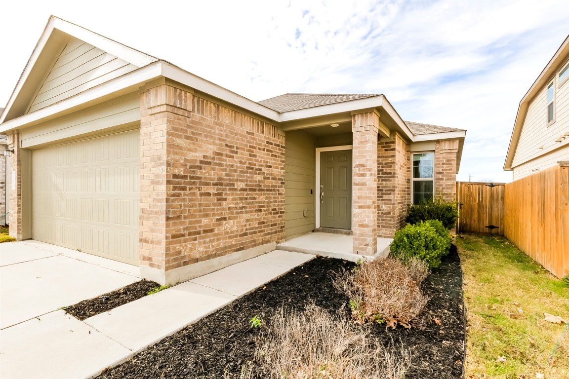545 Greatest Gift Way Jarrell, TX 76537 - Photo 4 of 34 View of front of property featuring brick siding, a garage, roof with shingles, and driveway