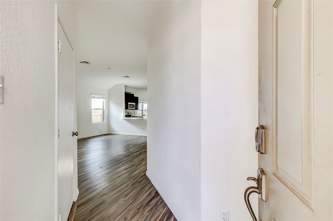 545 Greatest Gift Way Jarrell, TX 76537 - Photo 5 of 34 Hallway featuring dark wood finished floors and baseboards
