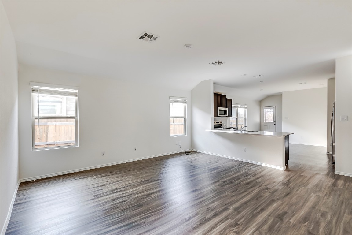 545 Greatest Gift Way Jarrell, TX 76537 - Photo 6 of 34 Unfurnished living room with dark wood finished floors and baseboards