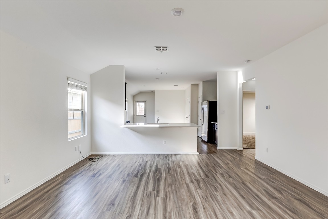 545 Greatest Gift Way Jarrell, TX 76537 - Photo 8 of 34 Unfurnished living room with dark wood finished floors and baseboards