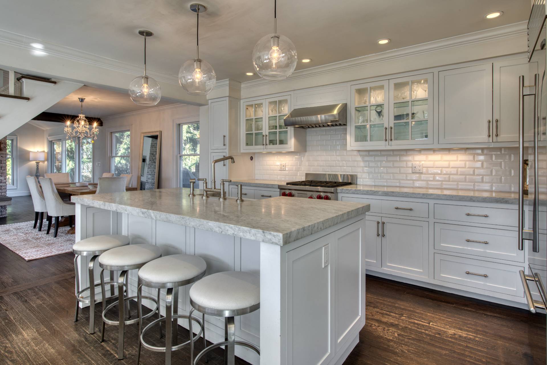 59 Dundee Lane Southampton, NY 11968 - Photo 2 of 10 a kitchen with stainless steel appliances kitchen island granite countertop a table chairs in it and wooden floors