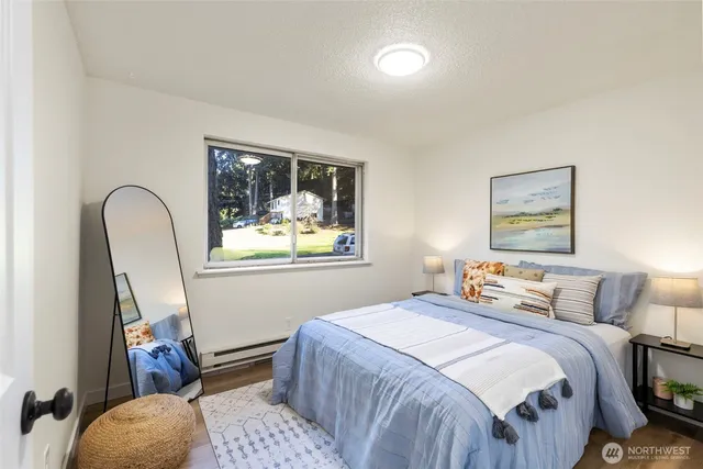 a bedroom with a bed and a painting on the wall