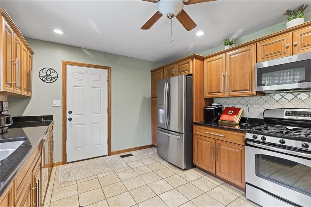 381 Golden Grove Road Baden, PA 15005 - Photo 12 of 38 a kitchen with stainless steel appliances granite countertop a refrigerator oven a sink dishwasher and white cabinets with wooden floor