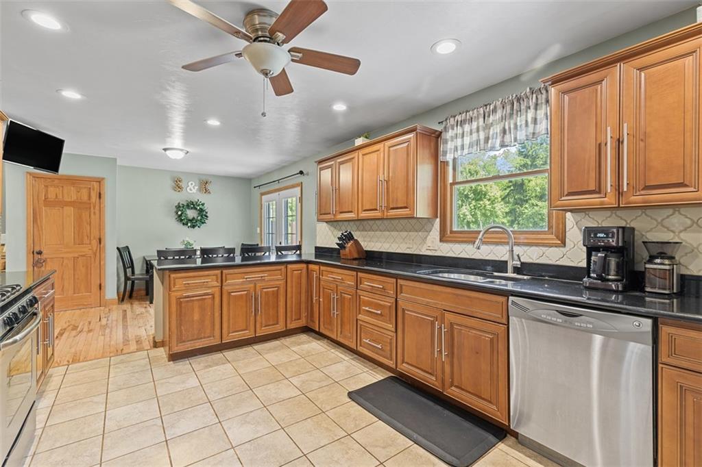 381 Golden Grove Road Baden, PA 15005 - Photo 13 of 38 a large kitchen with stainless steel appliances granite countertop a stove a sink and a microwave