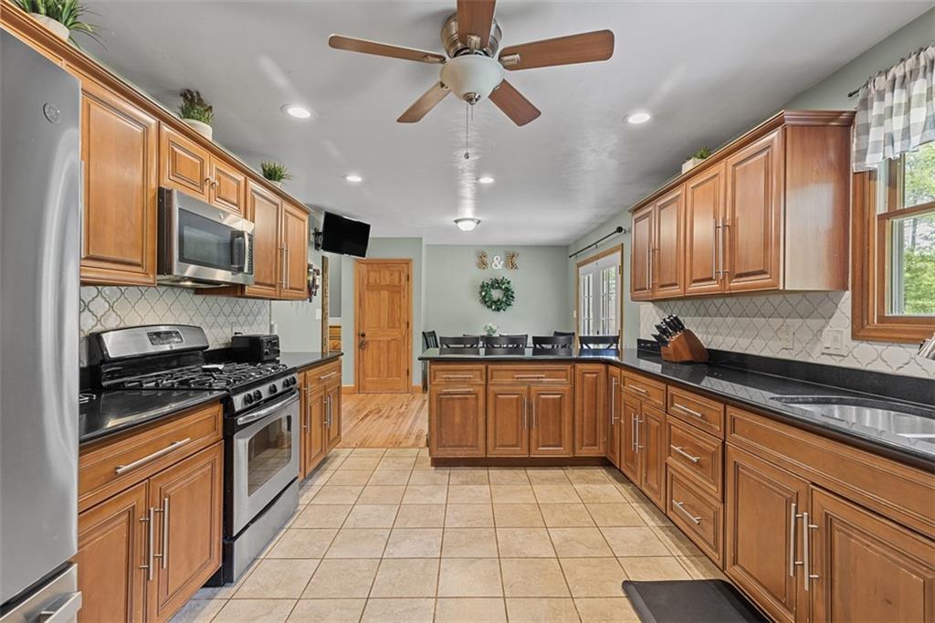 381 Golden Grove Road Baden, PA 15005 - Photo 14 of 38 a kitchen with stainless steel appliances granite countertop a stove sink microwave and cabinets