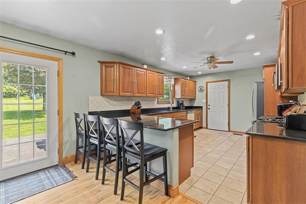 381 Golden Grove Road Baden, PA 15005 - Photo 10 of 38 a kitchen with stainless steel appliances granite countertop table chairs sink and cabinets