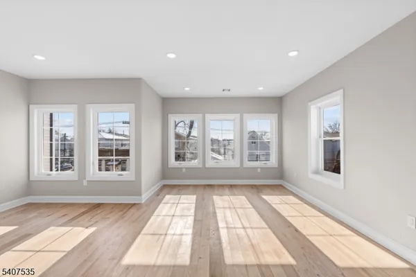 a large kitchen with kitchen island a large island wooden floor and a large window