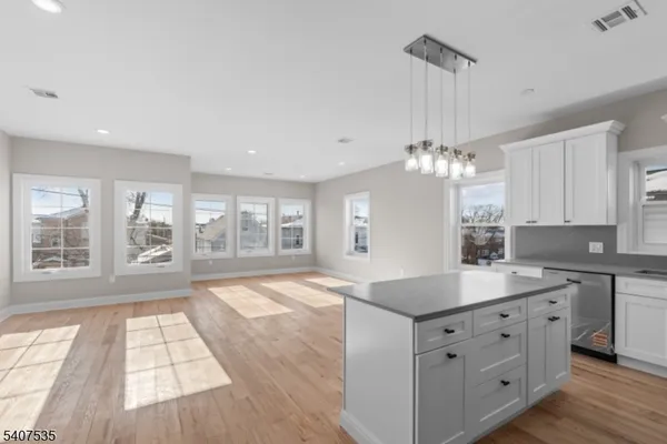 a kitchen with a sink dishwasher a refrigerator and cabinets