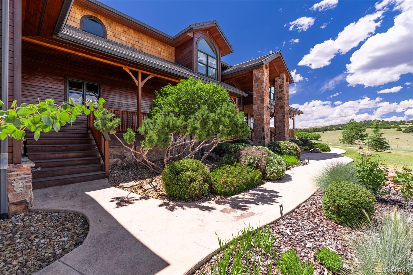157 Cap Rock Road Canon City, CO 81212 - Photo 4 of 50 a view of a house with a small yard plants and large tree