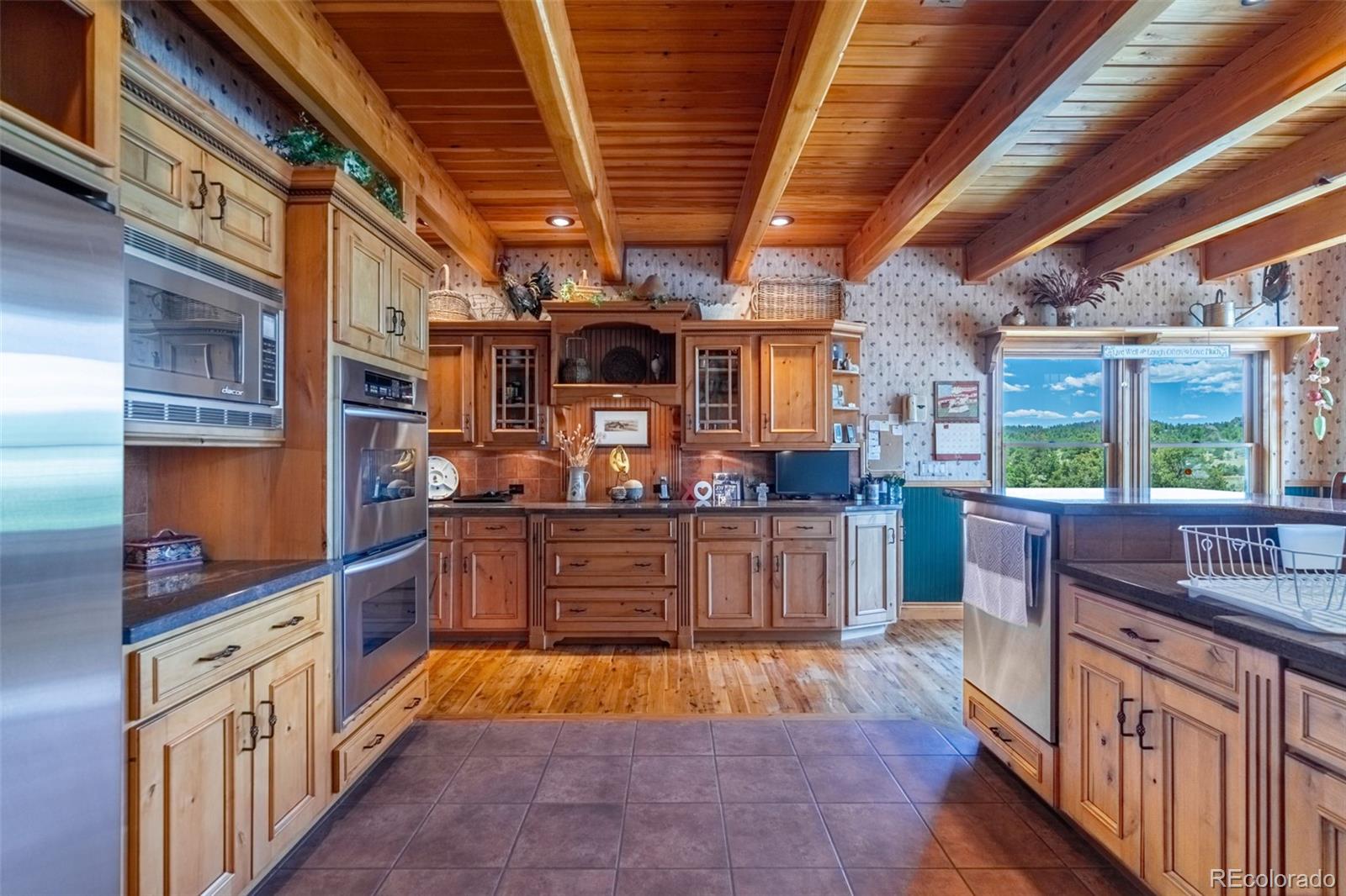 157 Cap Rock Road Canon City, CO 81212 - Photo 7 of 50 a kitchen with stainless steel appliances granite countertop a stove a sink dishwasher and wooden cabinets with large window