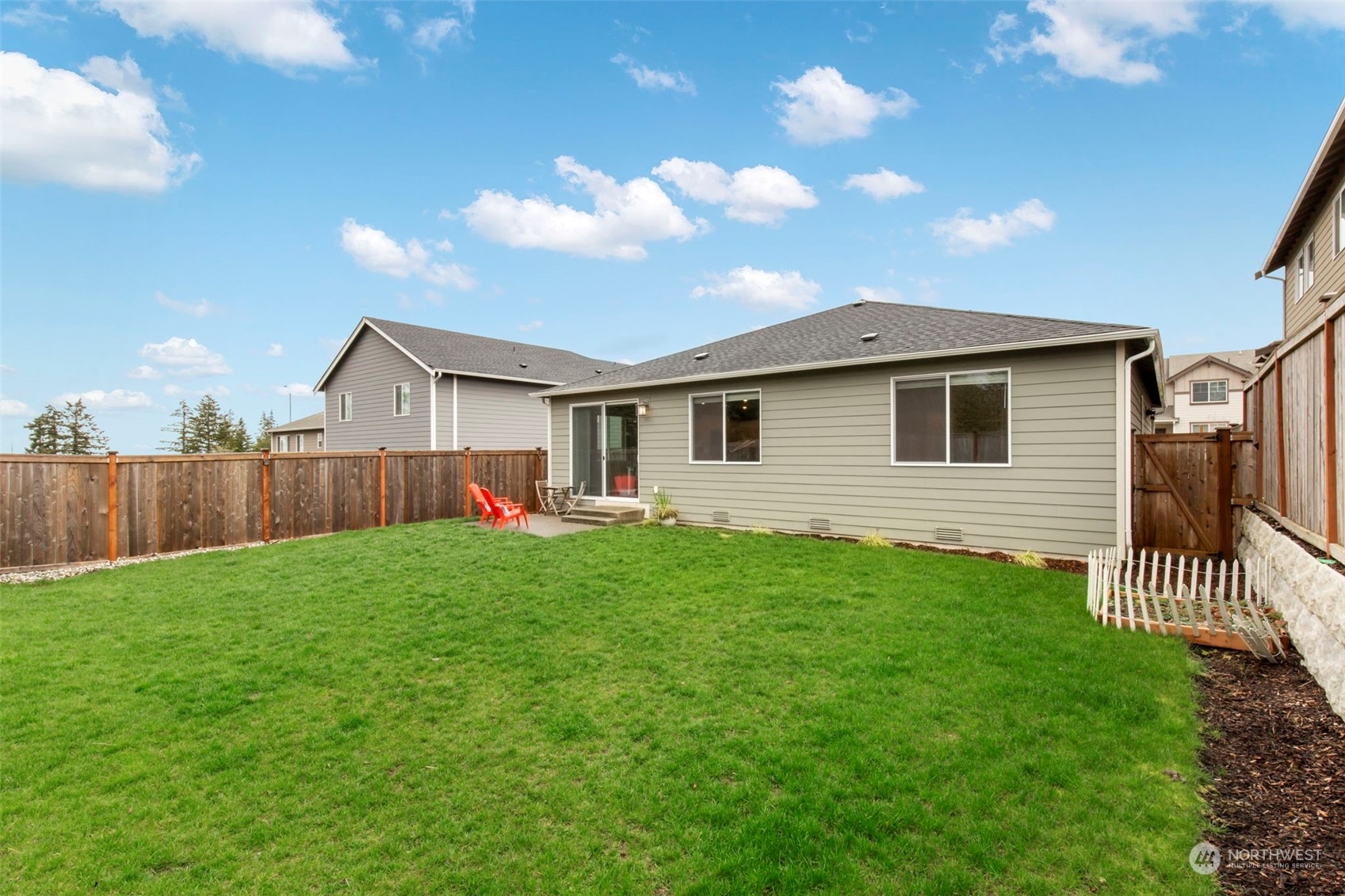 1496 Baker Heights Loop Bremerton, WA 98312 - Photo 27 of 27 a view of a backyard with plants and wooden fence