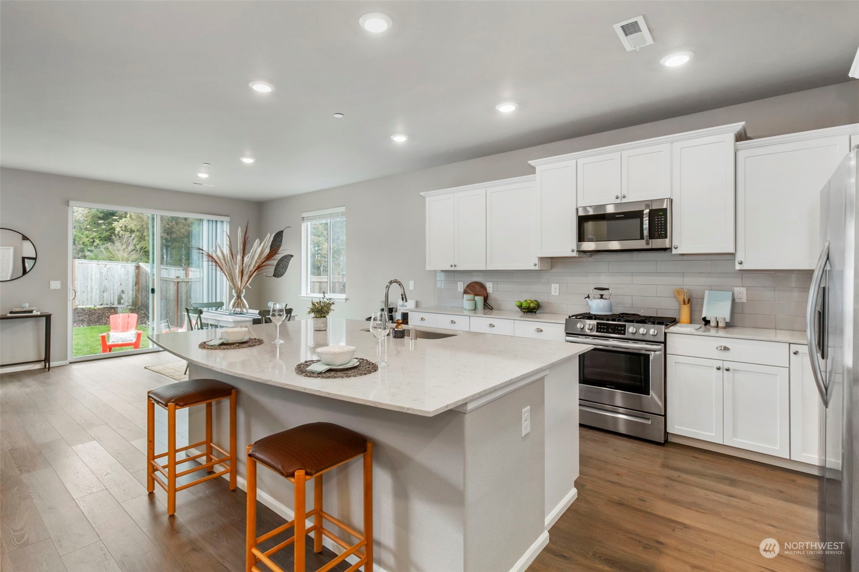 1496 Baker Heights Loop Bremerton, WA 98312 - Photo 9 of 27 a kitchen with stainless steel appliances granite countertop a stove top oven a sink a refrigerator and white cabinets with wooden floor