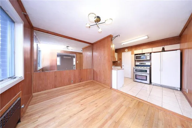 a view of a hallway with wooden floor and closet