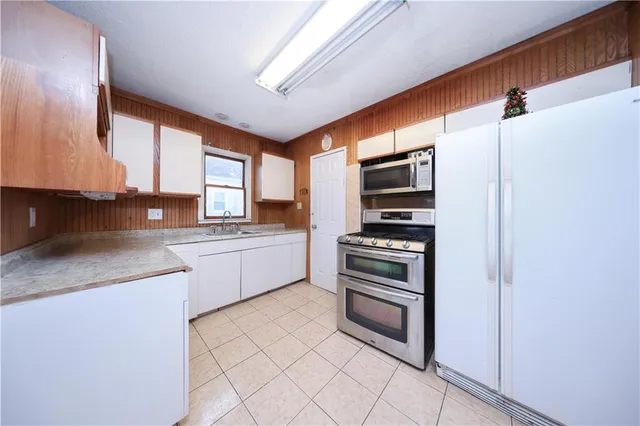 a kitchen with stainless steel appliances granite countertop a refrigerator and a stove top oven