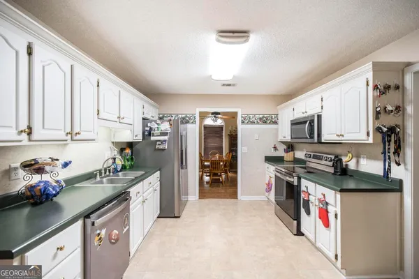a kitchen with stainless steel appliances granite countertop a sink stove and cabinets
