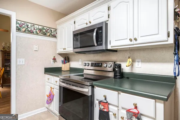 a kitchen with stainless steel appliances granite countertop a stove a microwave and cabinets