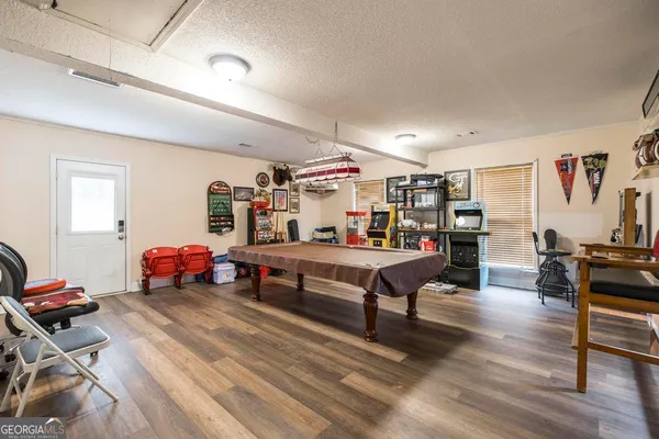 a living room with furniture a flat screen tv and gym equipment