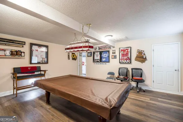 a living room with furniture pool table and window