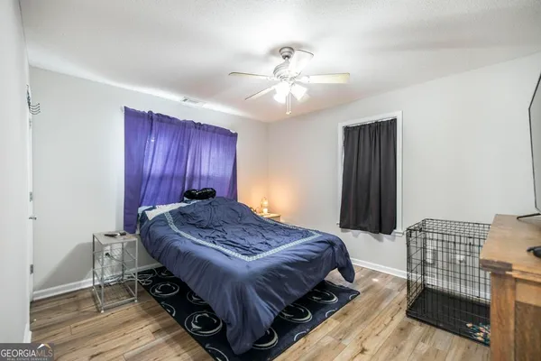 a bed sitting in a spacious bedroom next to a window and a chandelier