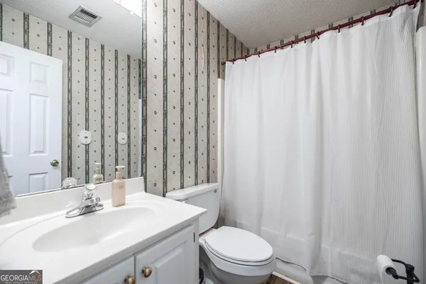 a bathroom with a sink a toilet and shower curtain