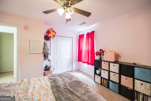 a bedroom with furniture and a chandelier fan