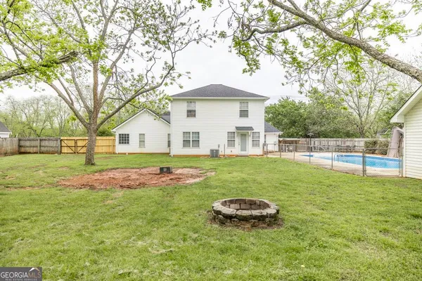 a view of a house with backyard and tree