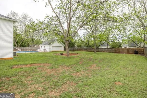 a view of a house with a big yard and large trees