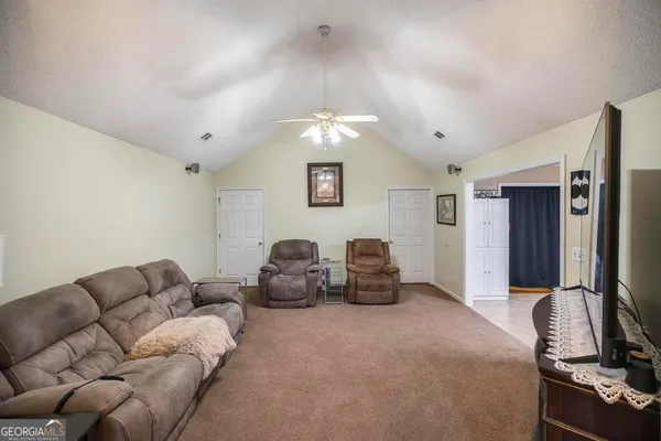 a living room with furniture a window and a flat screen tv