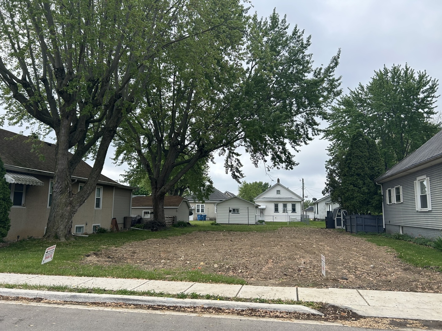 a view of a house with a yard and large trees